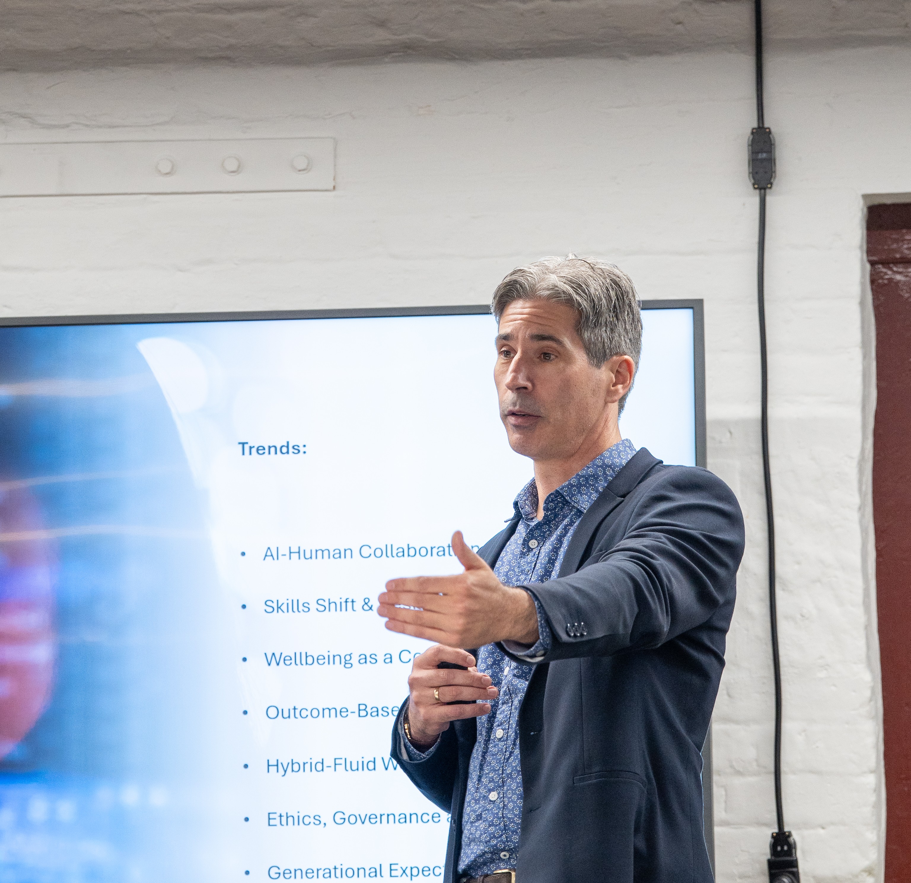 Trent McHugh presenting on AI-human collaboration, skills shifts, and workplace wellbeing trends